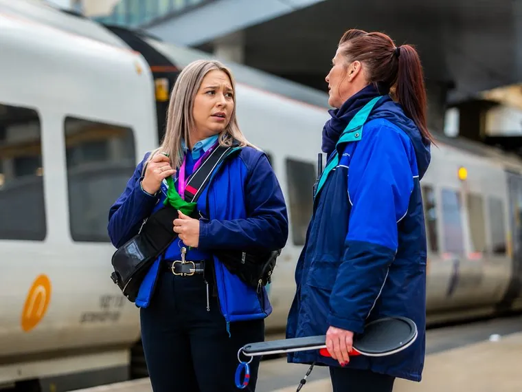A member of staff supporting a woman passenger at a help point